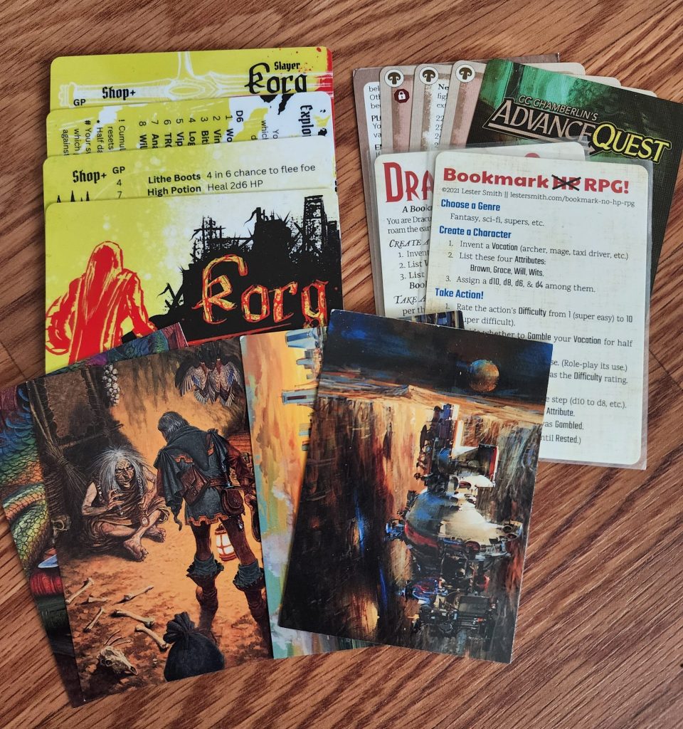 An assortment of art cards (artists John Berkey and Darrell K Sweet) and RPG game cards (Korg, Advance Quest, Bookmark No HP RPG) are laid out.