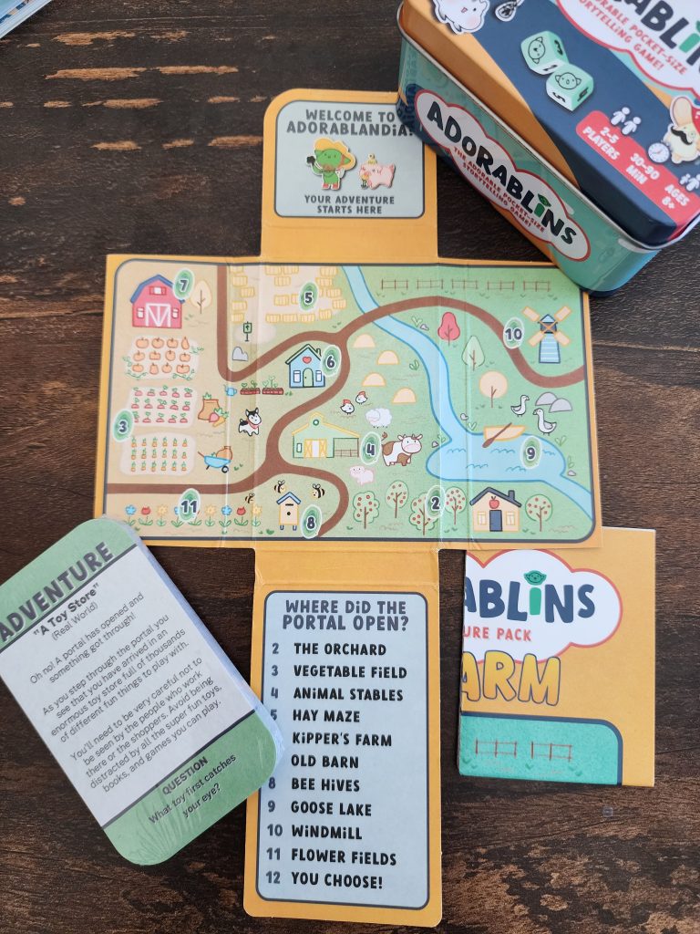 The fully-open interior of the Adorablins On the Farm adventure pack, with the most-interior flaps displaying a map of the Adorablins town, and the bottom flap having a "Where did the portal open" random chance table with options 2-12.